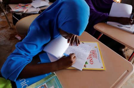 Zeinab, 14, writes in class at a school near a camp for internally displaced people from drought hit areas in Dollow, Somalia April 3, 2017. REUTERS/ Zohra Bensemra