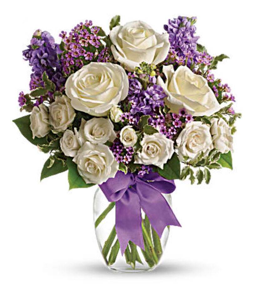 White roses with purple accenting in glass vase. (Photo: Teleflora)