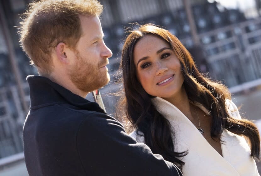 A man and woman look off in different directions