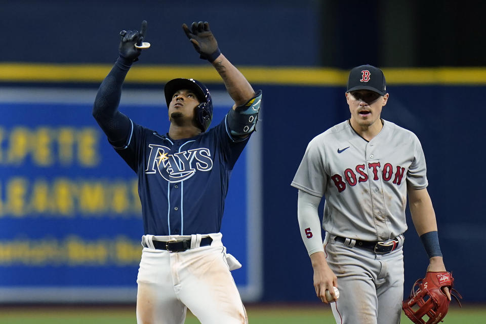 Tampa Bay Rays' Wander Franco, left, celebrates his double off Boston Red Sox relief pitcher Josh Taylor during the seventh inning of a baseball game Tuesday, June 22, 2021, in St. Petersburg, Fla. Looking on Boston's Kike Hernandez. (AP Photo/Chris O'Meara)