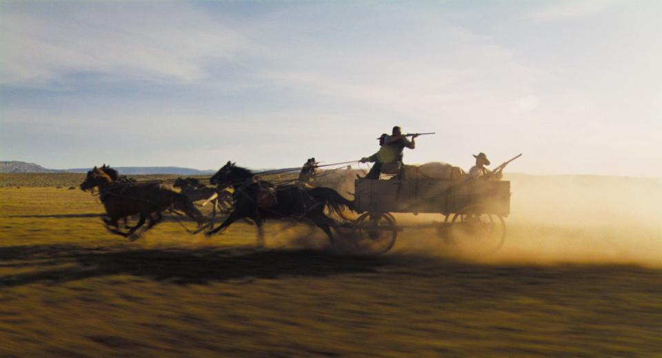 a group of people riding on a cart pulled by horses