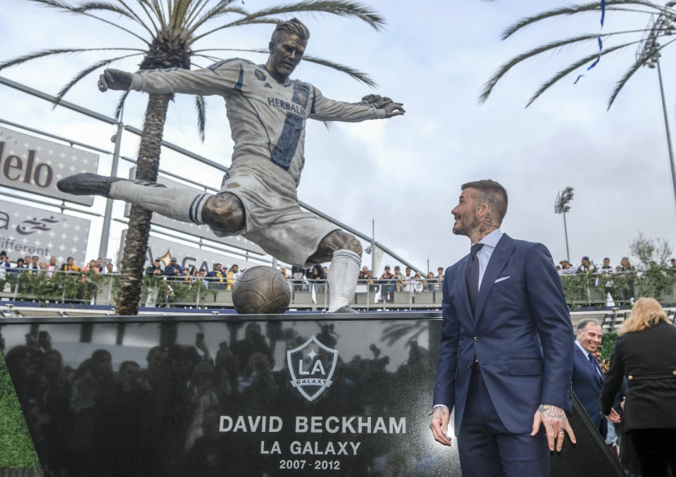 Former LA Galaxy MLS soccer midfielder David Beckham looks at a statue of himself at Legends Plaza in front of Dignity Health Sports Park in Carson, Calif., Saturday, March 2, 2019. (AP Photo/Ringo H.W. Chiu)