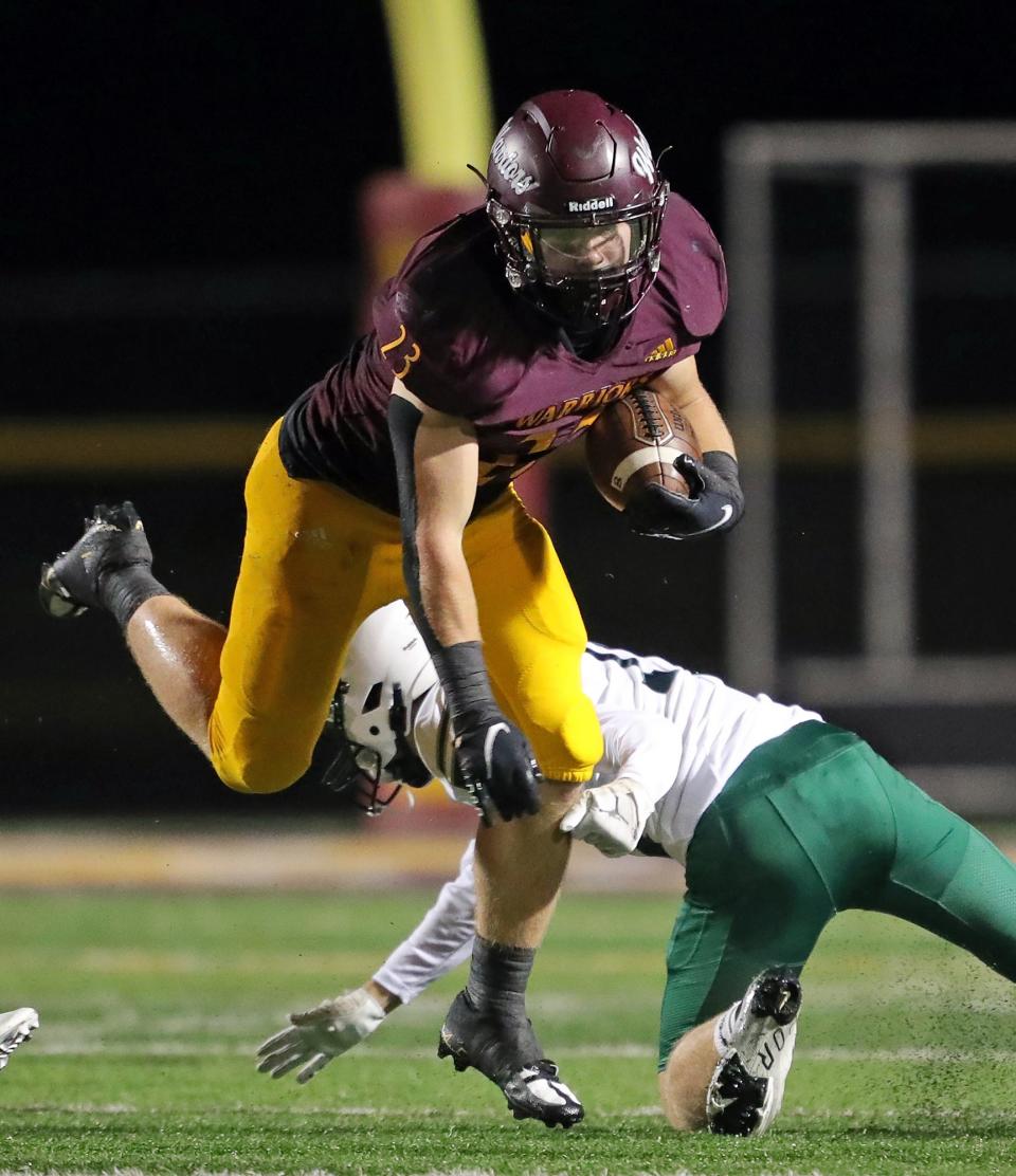 Walsh Jesuit running back Justin Bremner breaks away from a Lake Catholic defender as he runs for yardage during the first half of a high school football game, Friday, Oct. 7, 2022, in Cuyahoga Falls, Ohio.