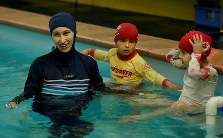 Australian muslim swimming instructor Fadila Chafic wears her full-length 'burkina' swimsuit during a swimming lesson with her children Taaleen (R) and Ibrahim at swimming pool in Sydney, August 23, 2016. REUTERS/Jason Reed