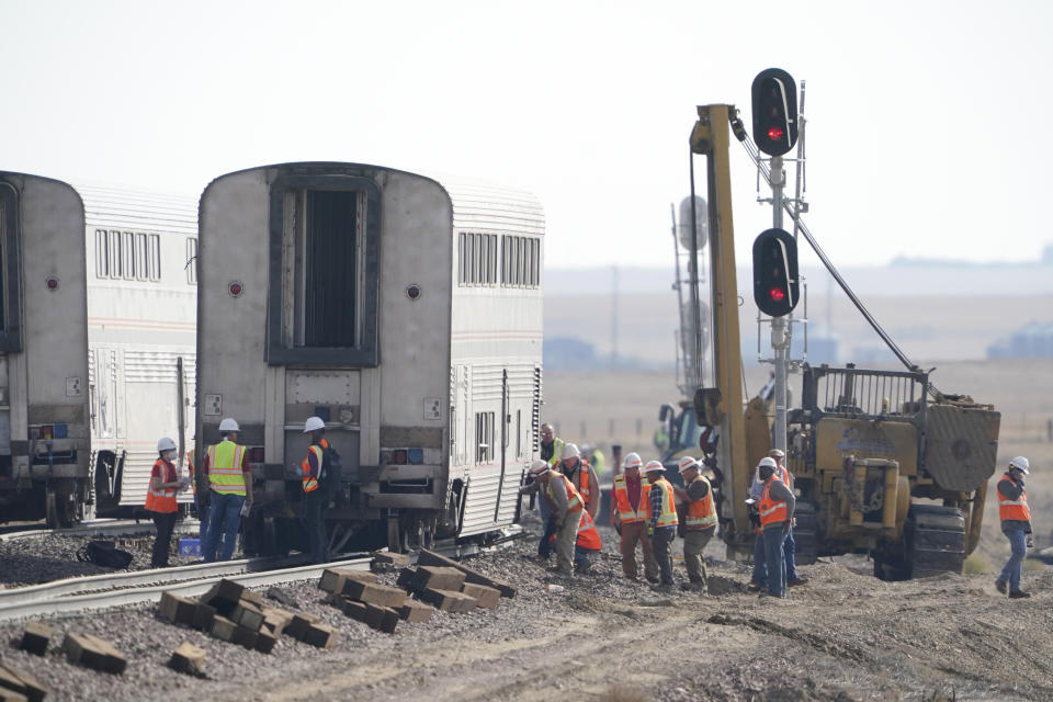 FILE - In this Sept. 27, 2021, file photo, workers examine cars from an Amtrak train that derailed near Joplin, Mont. A preliminary report released Tuesday, Oct. 16, 2021, on the derailment of an Amtrak train in north-central Montana last month that killed three people and injured dozens more gave no information on the cause of the accident. (AP Photo/Ted S. Warren, File)