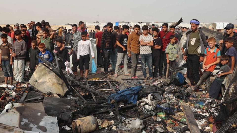 Palestinians gather at the site of an Israeli strike on a camp for internally displaced people in Rafah after the air strike by Israel. (Photo by Eyad Baba / AFP)