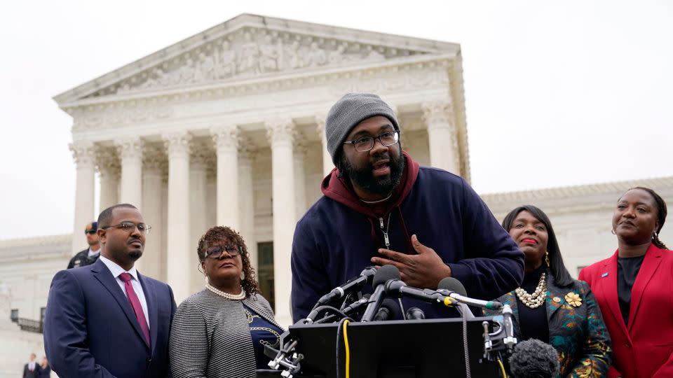 Evan Milligan, center, plaintiff in Merrill v. Milligan, an Alabama redistricting case that could have far-reaching effects on minority voting power across the United States, speaks with reporters following oral arguments at the Supreme Court in Washington, Oct. 4, 2022.  - Patrick Semansky/AP