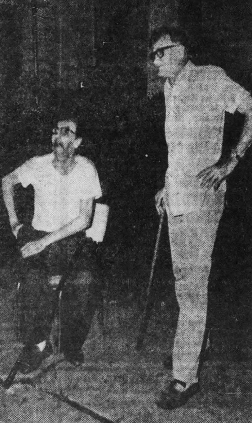 Cliff Gebhardt, seated, and Gene Sabo watched firemen fight the blaze at their rooming house on Bayard Street, New Brunswick, on Wednesday, July 11, 1973. The two were rescued from the building by police.