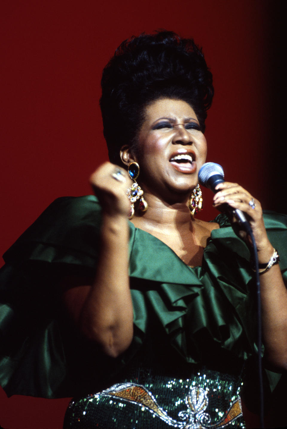 <p>Aretha Franklin tritt 1986 in einem extravaganten grünen Rüschenkleid mit Metallicdetails auf, dazu Chandelier-Ohrringe und eine überlebensgroße Pompadour-Frisur. (Foto von Al Pereira/Michael Ochs Archives/Getty Images) </p>