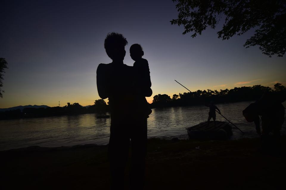 <p>A Honduran migrant heading in a caravan to the U.S. carries a baby in Ciudad Hidalgo, Mexico, after crossing the Suchiate river between Guatemala and Mexico in a makeshift raft on Oct. 22, 2018. (Photo: Pedro Pardo/AFP/Getty Images) </p>