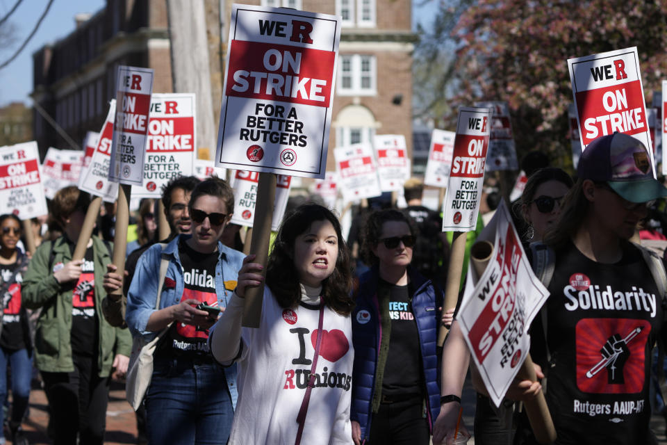 Strikers march in front of Rutgers' buildings in New Brunswick, N.J., Monday, April 10, 2023. Thousands of professors, part-time lecturers and graduate student workers at New Jersey's flagship university have gone on strike — the first such job action in the school's 257-year history. (AP Photo/Seth Wenig)