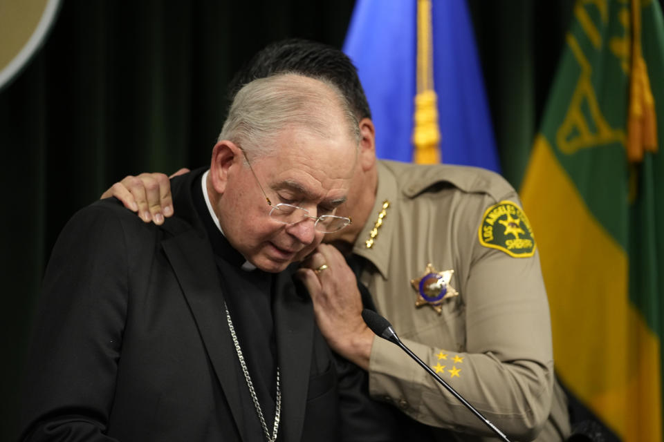 Los Angeles County Sheriff Robert Luna, right, hugs Archbishop of Los Angeles, Jose H. Gomez as he speaks during a news conference announcing an arrest has been made in connection to the murder of Catholic auxiliary bishop David O'Connell, who was fatally shot over the weekend in Hacienda Heights, at a news conference at the Hall of Justice Monday, Feb. 20, 2023 in Los Angeles. Luna says a SWAT team arrested Carlos Medina in the morning at his home in Torrance, about 35 miles (56 kilometers), southwest of Hacienda Heights, where Auxiliary Bishop David O'Connell was killed. (AP Photo/Damian Dovarganes)