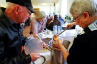 An old man in need receives vegetable soup in a plastic cup to take away from the soup kitchen "Kana" in a poor district of the city of Dortmund, western Germany, April 7, 2017. REUTERS/Wolfgang Rattay