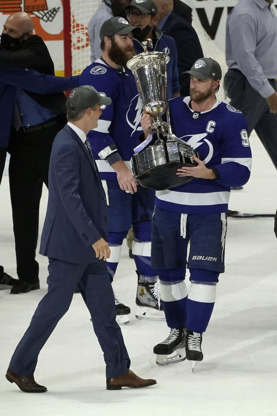 Tampa Bay Lightning center Steven Stamkos (91) holds up the Prince of Wales trophy for head coach Jon Cooper after defeating the New York Islanders during Game 7 of an NHL hockey Stanley Cup semifinal playoff series Friday, June 25, 2021, in Tampa, Fla. (AP Photo/Chris O'Meara)