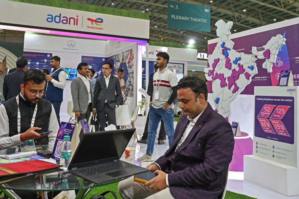 Business visitors sit for a discussion at the Adani Gas stall during an exhibition held as part of the ongoing 'India Energy Week 2023' under Indias G20 Presidency, in Bengaluru on February 7, 2023. (Photo by Manjunath KIRAN / AFP) (Photo by MANJUNATH KIRAN/AFP via Getty Images)
