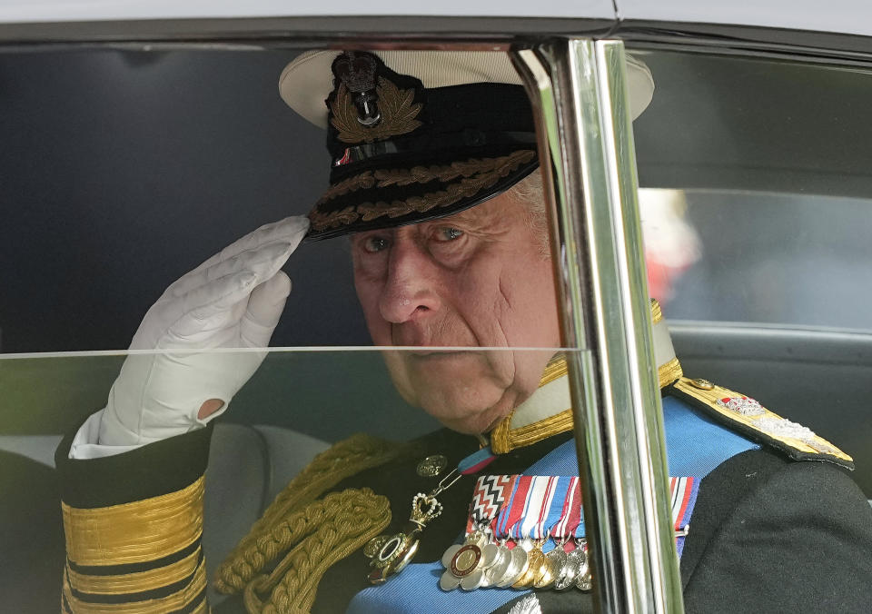 FILE - King Charles III salutes as he leaves Westminster Abbey following the state funeral service of Queen Elizabeth II in Westminster Abbey in central London, England, Monday Sept. 19, 2022.After waiting 74 years to become king, Charles has used his first six months on the throne to meet faith leaders across the country, reshuffle royal residences and stage his first overseas state visit. With the coronation just weeks away, Charles and the Buckingham Palace machine are working at top speed to show the new king at work. (AP Photo/Martin Meissner, File)