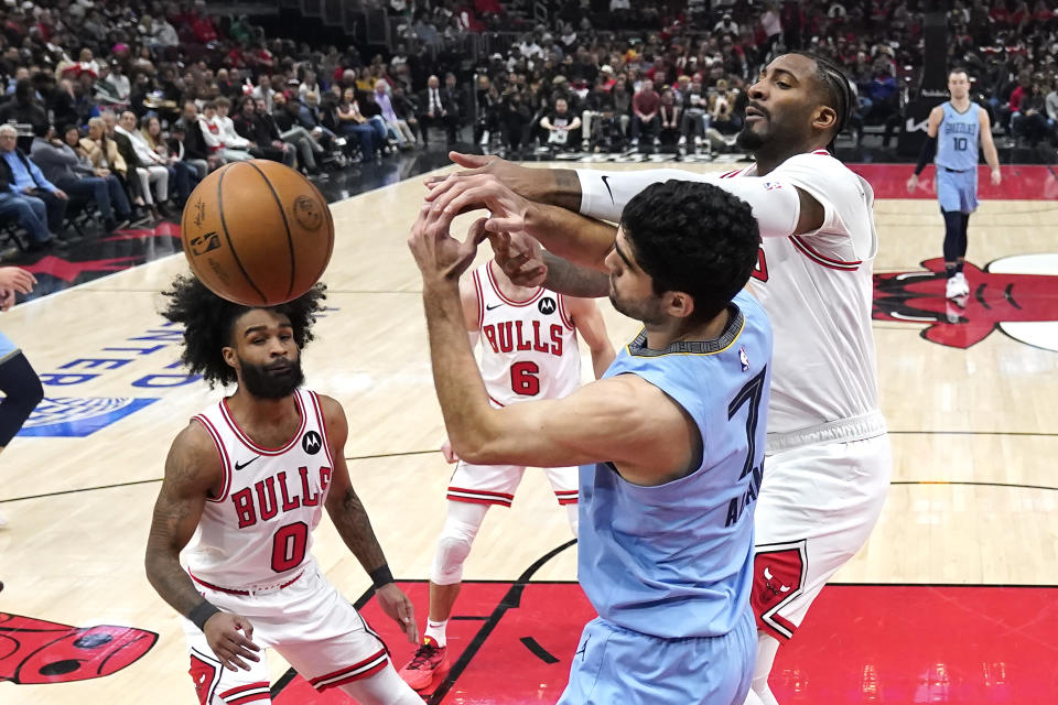 Memphis Grizzlies' Santi Aldama (7) and Chicago Bulls' Andre Drummond reach for the ball as Coby White watches during the first half of an NBA basketball game Saturday, Jan. 20, 2024, in Chicago. (AP Photo/Charles Rex Arbogast)