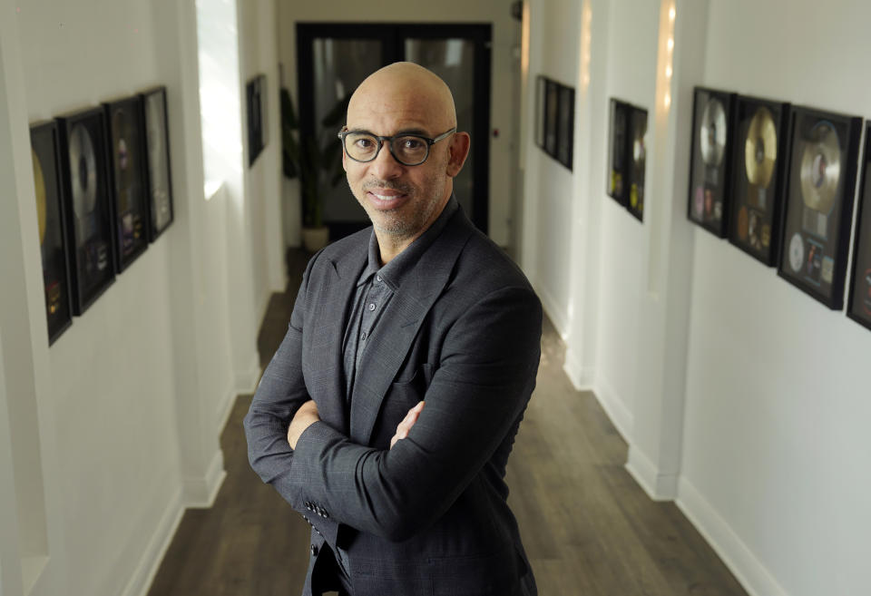 Harvey Mason jr., CEO of The Recording Academy, poses amongst commemorative records he has worked on during his career, at Harvey Mason Media music production studios, Monday, Oct. 11, 2021, in Burbank, Calif. (AP Photo/Chris Pizzello)