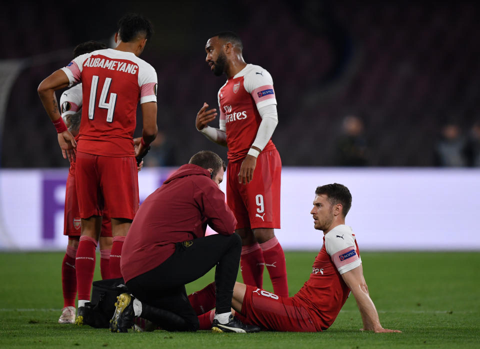 Aaron Ramsey receives treatment for hamstring injury against Napoli (Photo by Stuart Franklin/Getty Images)