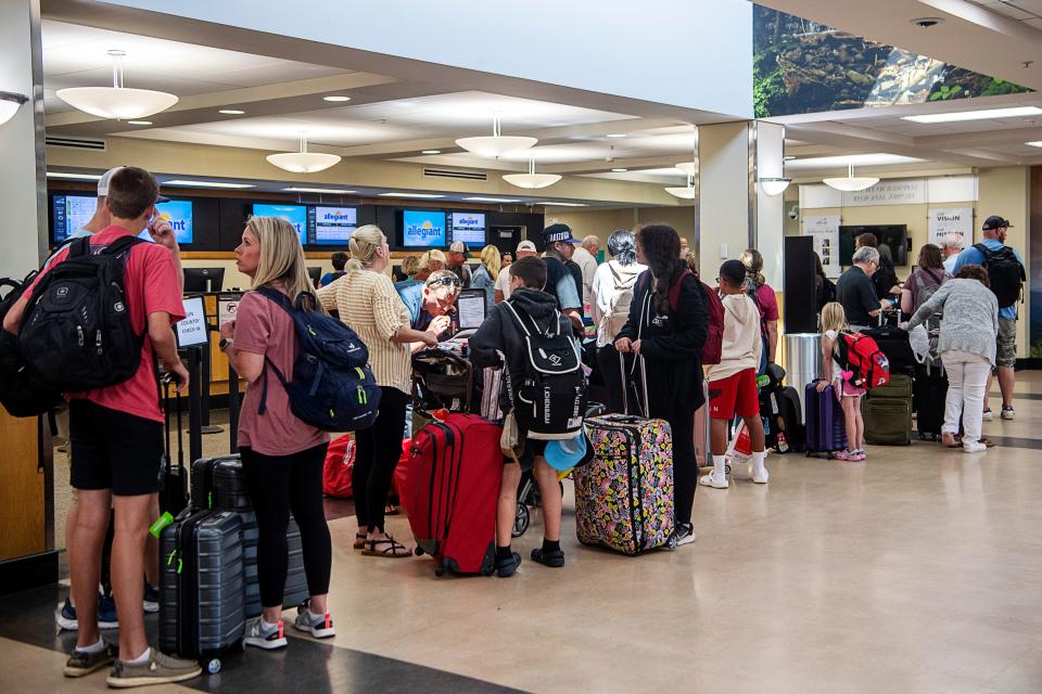 Travelers wait in line to check bags with Allegiant Air at the Asheville Airport July 14, 2023.