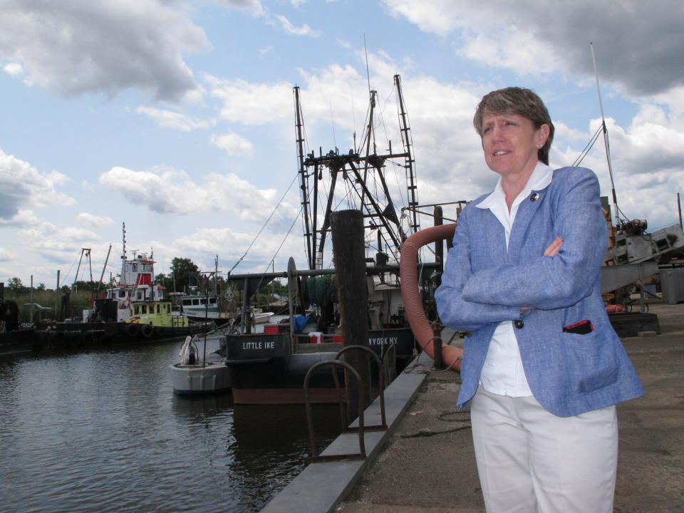 In this June 3, 2019 photo Cindy Zipf, executive director of the Clean Ocean Action environmental group, discusses a plan to build a natural gas pipeline that would run near this Middletown, N.J,. fishing depot. New Jersey environmental officials are due to decide Wednesday, June 5 on key permits for a nearly $1 billion pipeline that would bring natural gas from Pennsylvania through New Jersey, out into Raritan Bay and into the ocean before reaching New York and Long Island. (AP Photo/Wayne Parry)