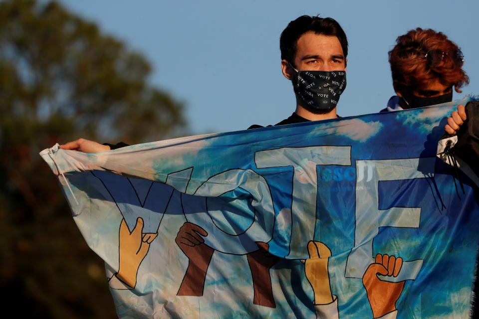 Un partisan tient un drapeau alors que la vice-présidente élue des États-Unis, Kamala Harris, et les candidats démocrates au Sénat américain Jon Ossoff et le révérend Raphael Warnock organisent un événement de campagne avant le second tour des élections en Géorgie à Savannah, Géorgie, États-Unis, le 3 janvier 2021. REUTERS/Mike Segar