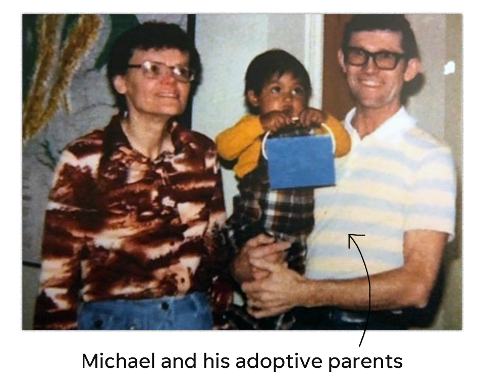 Michael Libberton's adoptive parents hold him, center, as the family poses for a picture.