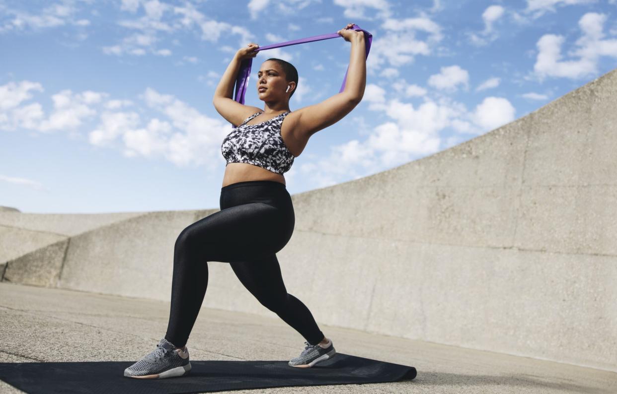 Best Black Leggings, According to Customer Reviews , Plus size woman exercising with resistance band