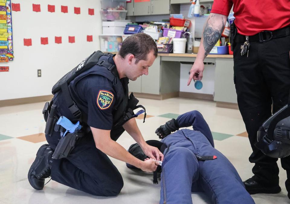 Palm Beach Police officer Steven Quinn practices putting a tourniquet on a victim Friday during active shooter training at Palm Beach Public School.