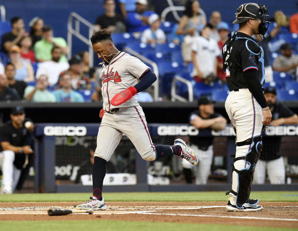 Atlanta Braves' Ozzie Albies scores a run during the first inning of the team's baseball game against the Miami Marlins, Friday, April 12, 2024, in Miami. (AP Photo/Michael Laughlin)