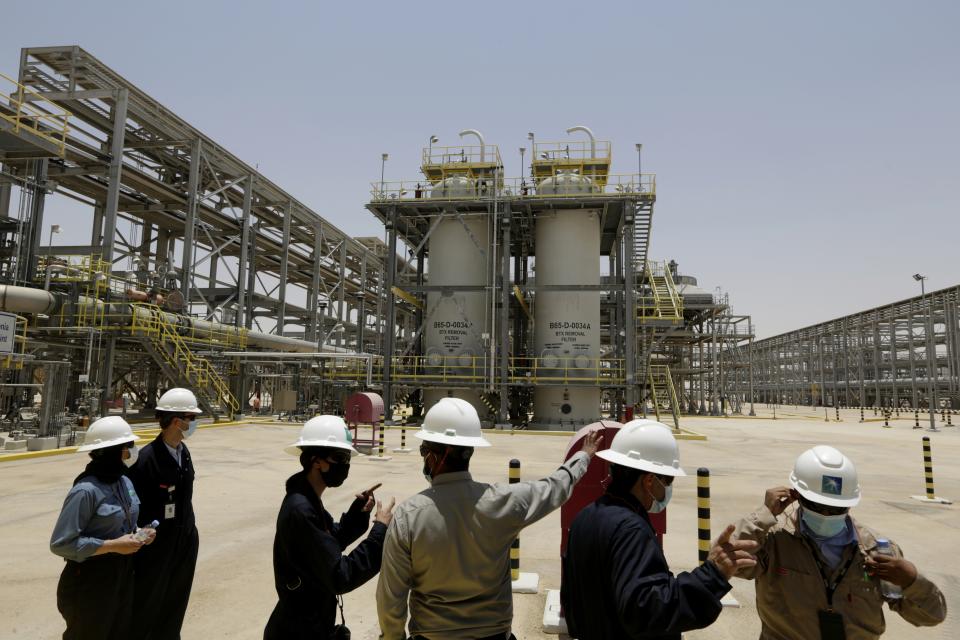 FILE - In this June 28, 2021, file photo, Saudi Aramco engineers and journalists look at the Hawiyah Natural Gas Liquids Recovery Plant in Hawiyah, in the Eastern Province of Saudi Arabia. One of the world's largest oil producers, Saudi Arabia, announced on Saturday, Oct. 23, it aims to reach “net zero” greenhouse gas emissions by 2060, joining more than 100 countries in a global effort to try and curb man-made climate change. (AP Photo/Amr Nabil, File)