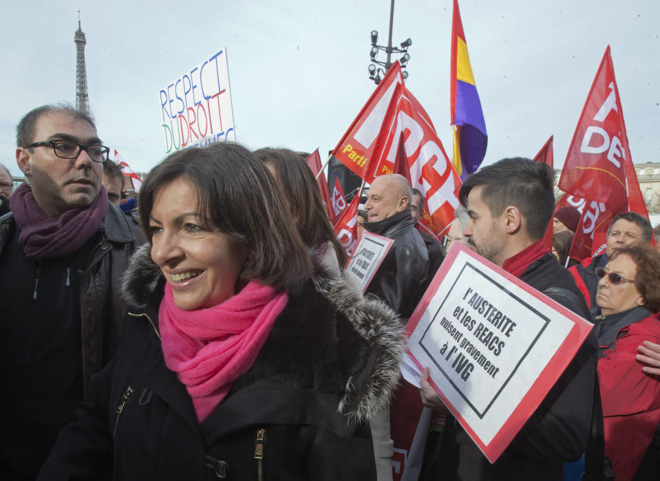 Socialist candidate to become mayor of Paris, Anne Hidalgo, left, protests against the new abortion law in Spain, during a rally in Paris, Saturday Feb. 1, 2014. Spain's conservative government approved tight restrictions on abortion, allowing the practice only in the case of rape or when there is a serious health risk. Placard on right reads, "austerity and reactionary politics harm severely induced abortion". (AP Photo/Michel Euler)