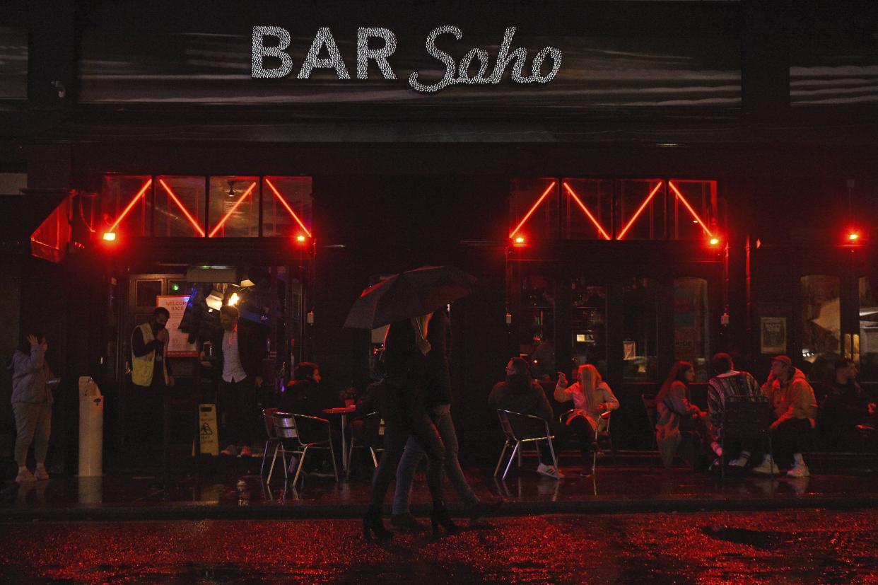 People drink outside a bar in Soho, London, ahead of the 10 p.m. curfew pubs and restaurants are subject to in order to combat the rise in coronavirus cases in England on Friday, Oct. 2, 2020.