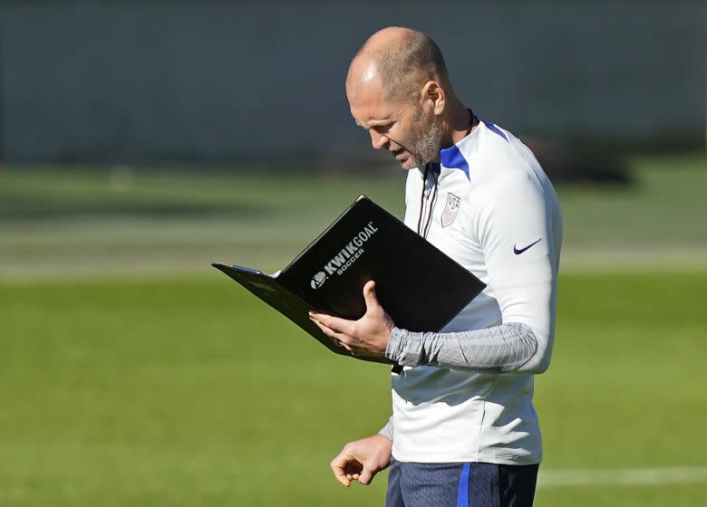 FILE - US head coach Gregg Berhalter reads a book during a training session of the US soccer team in Cologne, Germany, prior to a friendly match against Japan, Thursday, Sept. 22, 2022. (AP Photo/Martin Meissner, File)