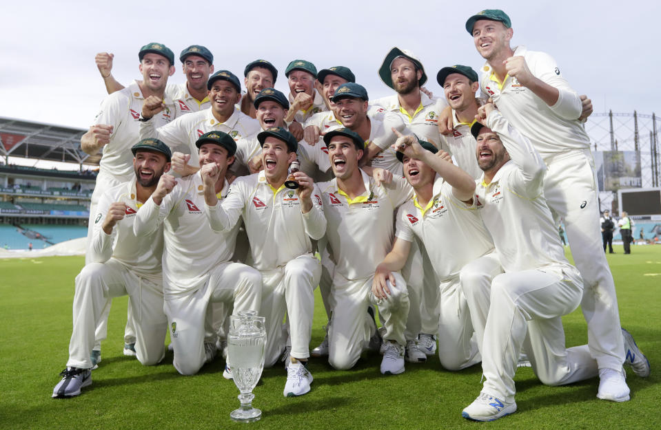 FILE - In this Sept. 15, 2019, file photo, Australia's cricket team poses for photographers with the Ashes Urn after the fourth day of the fifth Ashes cricket test match between England and Australia at the Oval cricket ground in London. Australia is set to host Afghanistan for a cricket test for the first time before taking on England in the Ashes series starting in December. (AP Photo/Kirsty Wigglesworth,File)