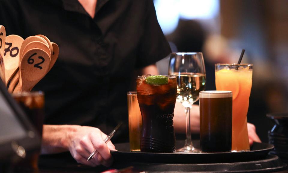 <span>A waitress with drinks. The reading on the S&P Global services purchasing managers’ index slowed from 52.9 in May to 52.1 in June.</span><span>Photograph: Bloomberg/Getty Images</span>
