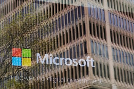 FILE PHOTO: An promotional video plays behind a window reflecting a nearby building at the Microsoft office in Cambridge, Massachusetts, U.S. on May 15, 2017. REUTERS/Brian Snyder/File Photo