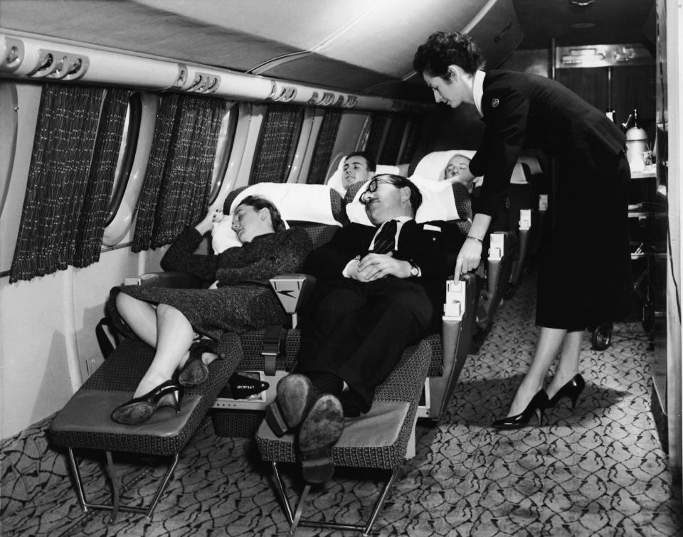 Passengers recline in seats on a first-class flight in the 1950s.