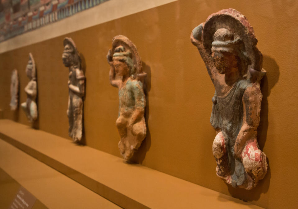 Bodhisattva holding up as lotus, right, and other sculptures of the Northern Wei Dynasty, 386-534 AD, are displayed in "Dunhuang: Buddhist Art at the Gateway of the Silk Road," at the China Institute, in New York, Tuesday, April 24, 2013. (AP Photo/Richard Drew)