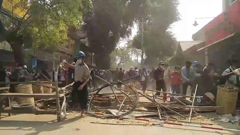 People flee away to safety during a protest in Mandalay