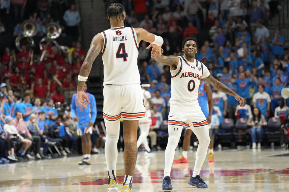 Auburn guard K.D. Johnson (0) and forward Johni Broome (4) celebrate after their team pulled ahead of Mississippi during the second half of an NCAA college basketball game, Saturday, Feb. 3, 2024, in Oxford, Miss. (AP Photo/Rogelio V. Solis)