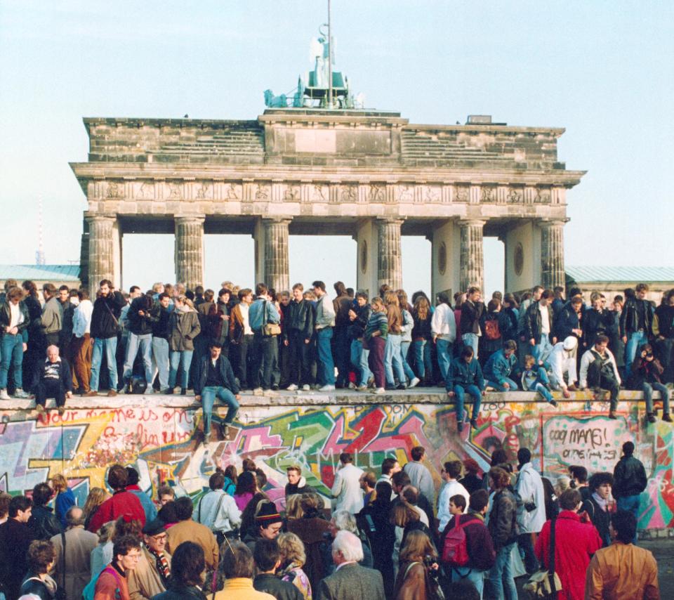 Germans from East and West stand on the Berlin Wall in front of the Brandenburg Gate on Nov. 10, 1989, one day after the Berlin Wall opened.