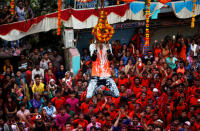 <p>A devotee hangs from a clay pot containing curd after breaking it during the Hindu festival of Janmashtami, marking the birth anniversary of Hindu Lord Krishna, in Ahmedabad, India, September 4, 2018. REUTERS/Amit Dave </p>