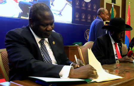 South Sudanese rebel leader Riek Machar (L) and South Sudan's President Salva Kiir sign a cease fire and power sharing agreement in Khartoum, Sudan August 5, 2018. REUTERS/Mohamed Nureldin Abdallah