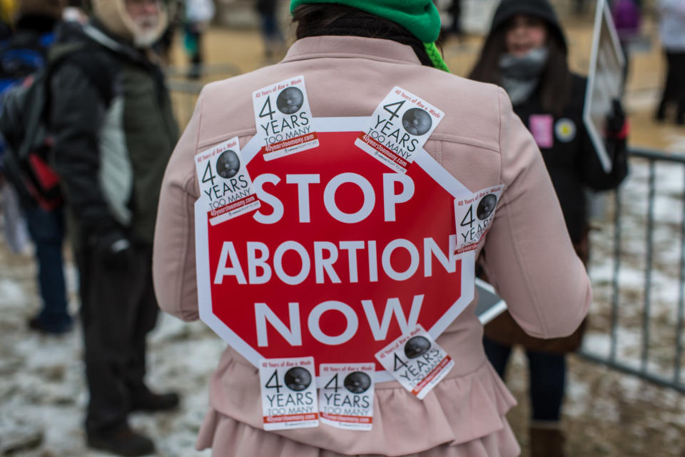 An anti-abortion protester has a sign stuck to her back with stickers at the March for Life on January 25, 2013 in Washington, DC. The pro-life gathering is held each year around the anniversary of the Roe v. Wade Supreme Court decision. (Photo by Brendan Hoffman/Getty Images)