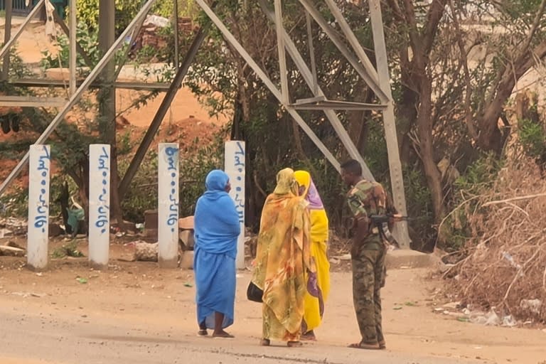 Un soldado habla con unas mujeres en una calle de la capital de Sudán, Jartum, el 6 de junio de 2023 (-)