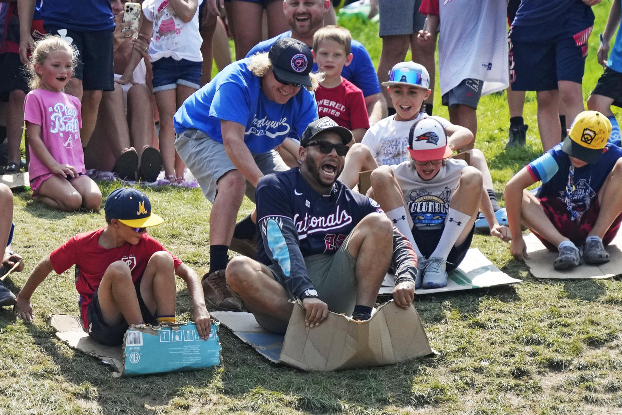 Washington Nationals' Dominic Smith slid down the hill with Little League Baseball World Series players on Sunday ahead of the Nationals' game against the Phillies. (AP/Gene J. Puskar)