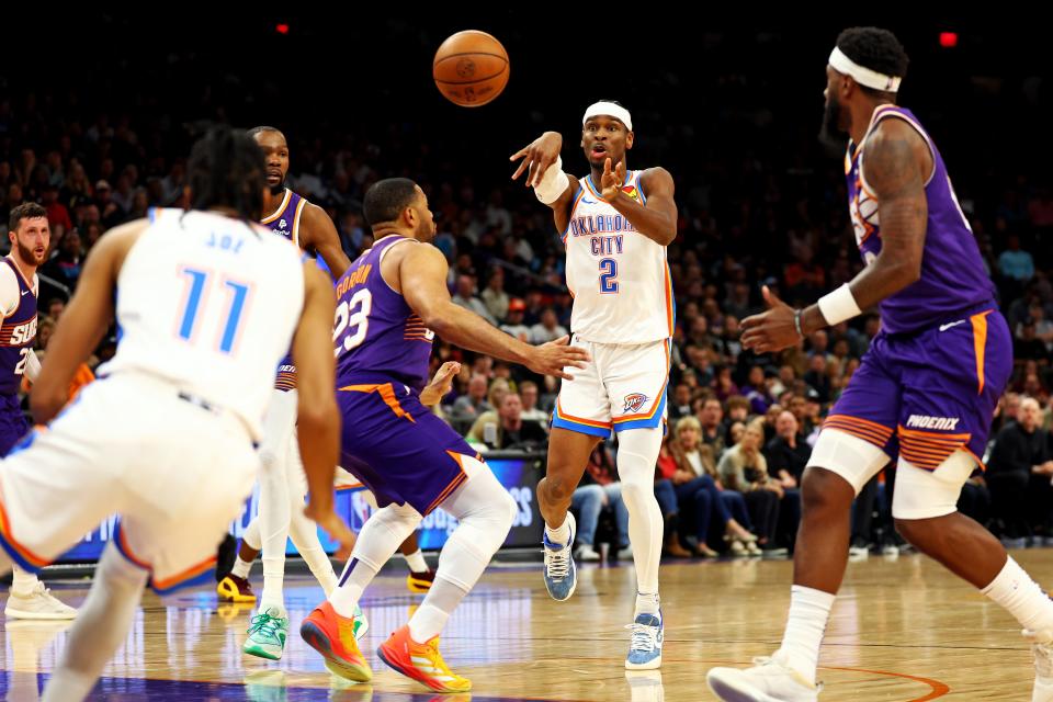 Thunder guard Shai Gilgeous-Alexander (2) passes the ball against Suns guard Eric Gordon (23) during the second quarter Sunday night at Footprint Center in Phoenix.