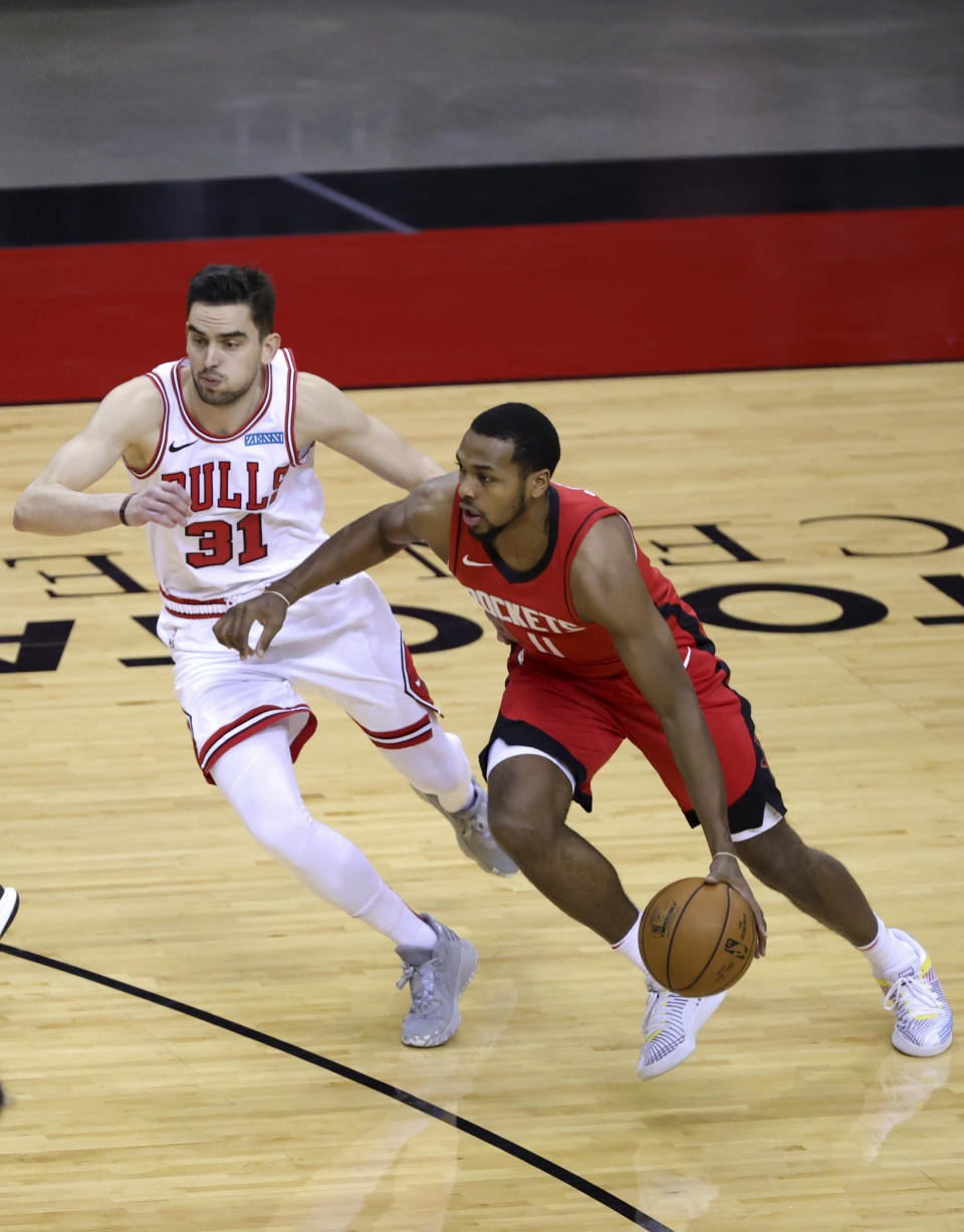 Houston Rockets' Sterling Brown, right, drives against Chicago Bulls' Tomas Satoransky (31) during the first quarter of an NBA basketball game Monday, Feb. 22, 2021, in Houston. (Carmen Mandato/Pool Photo via AP)