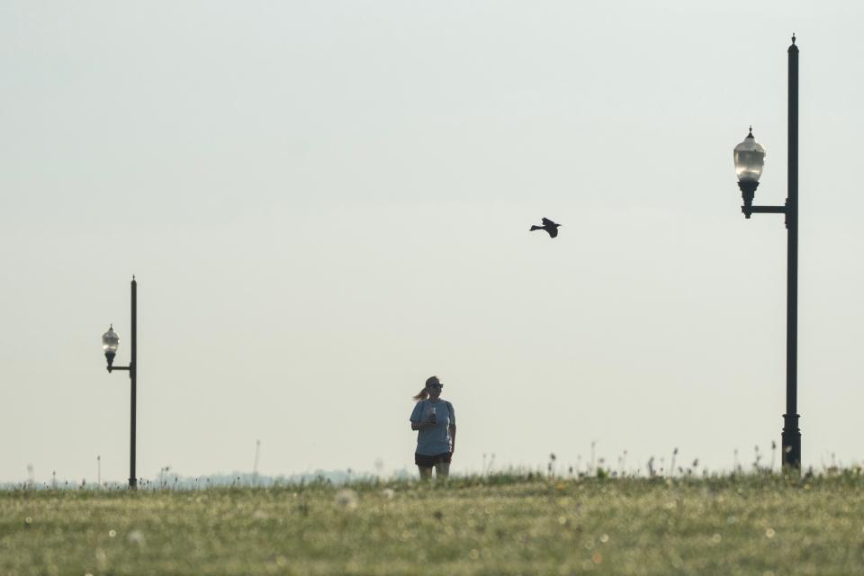 A woman talks along the path at Overpeck County Park in Ridgefield Park, NJ on Monday April 29, 2024.